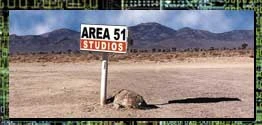 Area 51 Studios sign standing in a desert landscape next to a battered mailbox